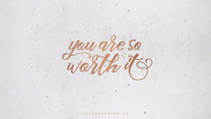 在斑點灰色背景上，銅色手寫文字寫著 you are so worth it。