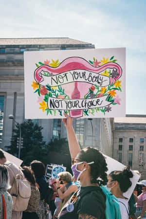 抗議者手持花卉抗議標語牌，上面寫著 Not Your Body Not Your Choice