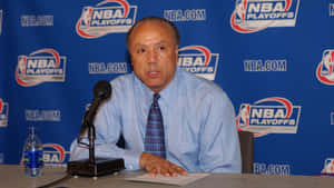 男子在NBA季後賽記者會上拿著麥克風和水瓶發言。