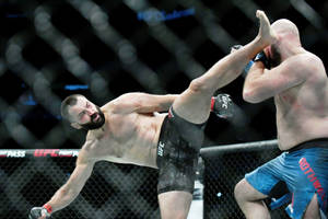 兩名MMA拳手在UFC八角籠內交戰，其中一人踢出高踢。