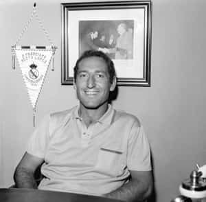 微笑的男人穿著Polo衫，身後有皇家馬德里1966年歐洲盃橫幅和裱框照片。 — 黑白 壁紙