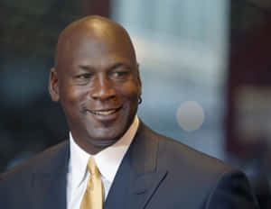 米高佐敦身穿西裝和金色領帶對著鏡頭微笑。 — Jordan 標誌 GIF 壁紙
