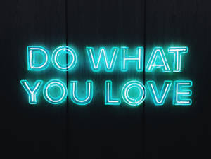 霓虹燈牌寫著 do what you love 在深色木背景上 — 語錄 壁紙