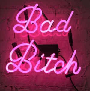 粉紅色霓虹燈牌寫著「Bad Bitch」在磚牆上，電線可見。
