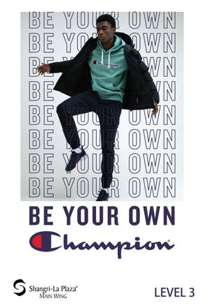 年輕男子穿著Champion服裝在品牌文字牆前擺姿勢。
