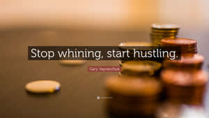 木質表面上的硬幣堆，附有「stop whining start hustling」名言。
