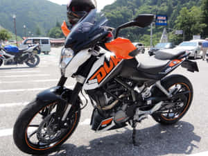 黑色和橙色的KTM Duke 390電單車停泊在陽光明媚的停車場。 — Bobber電單車 壁紙