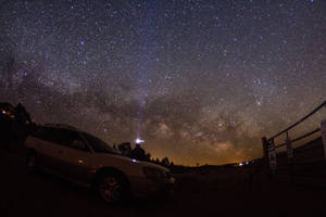 一輛車停在星空下，銀河可見