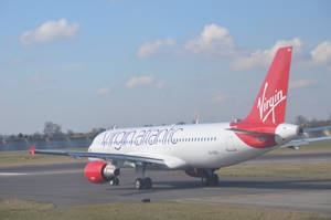 維珍航空飛機在跑道上，紅色機尾和引擎