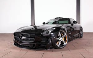 在工作室環境中，黑色 Mercedes SLS AMG 跑車配備金色制動卡鉗。 — 汽車 壁紙