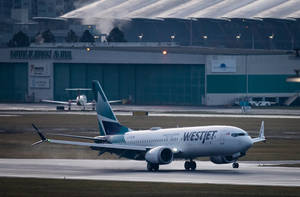 西捷航空飛機在黃昏時分在機場跑道上滑行