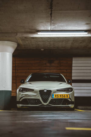 銀色Alfa Romeo跑車停在有木牆的地下車庫中。