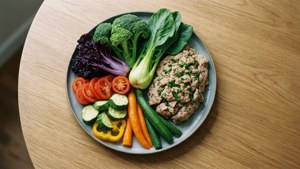 木桌上色彩繽紛的蔬菜和肉盤。
