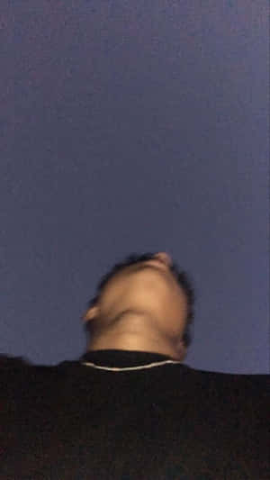 人向後傾斜頭部仰望暮色天空。