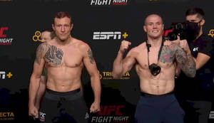 兩名有紋身、赤裸上身的MMA拳手在UFC稱重活動中擺姿勢。
