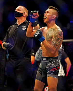 UFC拳手在八角籠內高舉拳頭慶祝勝利。