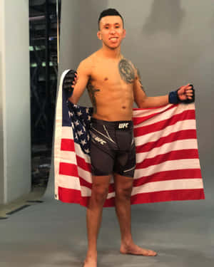 一位微笑的MMA拳手穿著UFC短褲手持美國國旗。