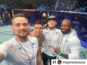 四名UFC選手和工作人員在現場活動中於八角籠內微笑。