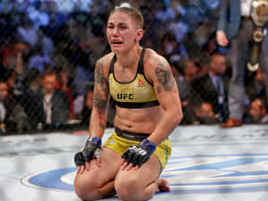 女性MMA拳手在比賽後於八角籠地上哭泣。