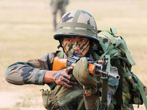 身穿迷彩裝備的士兵在草地上瞄準步槍
