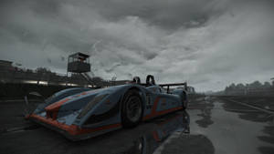 暴風雨中，潮濕賽道上的藍色和橙色賽車。 — Audi R8 GIF 壁紙