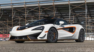 白色McLaren跑車帶有橙色飾邊停在賽道上。