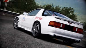 白色日產RX-7賽車在蜿蜒的道路上行駛，背景有樹木。