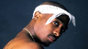 Tupac Shakur 喺攝影棚肖像中戴住白色頭巾同金鏈。