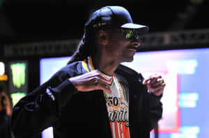 Snoop Dogg 在舞台上表演，戴著太陽眼鏡和金鏈，在強光下。