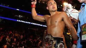 MMA拳手在UFC八角籠中高舉冠軍腰帶慶祝勝利。 — 搏擊會 GIF 壁紙