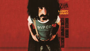 Frank Zappa 穿著綠色襯衫和吊帶褲，在紅色背景前，帶有專輯文字。