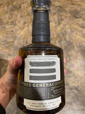 手拿Tres Generaciones Legacy Edition龍舌蘭酒瓶。