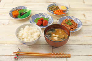 木桌上擺放米飯、味噌湯和小菜的日式餐點。 — 日本 壁紙
