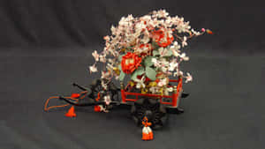裝飾性日本手推車，裝滿紅白花朵和橙色流蘇。 — 春天 壁紙
