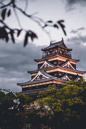 一座傳統的日本城堡在黃昏時亮起，周圍環繞著樹木。 — 小米Pad 9 Pro 壁紙