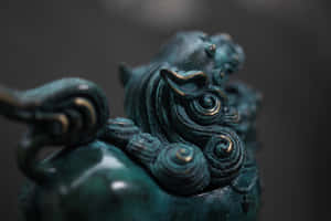 特寫一個青銅神話野獸雕像，帶有金色點綴和漩渦圖案。 — 龍 壁紙