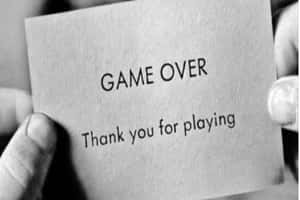 雙手拿著一張寫有「game over thank you for playing」的卡片。 — 語錄 壁紙