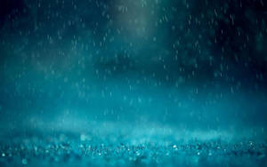 夜間雨落在草地上，背景有發光的散景燈光。