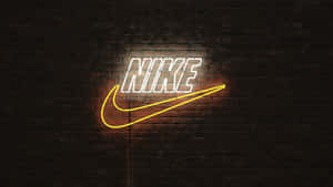 霓虹燈Nike標誌在深色磚牆上發光。