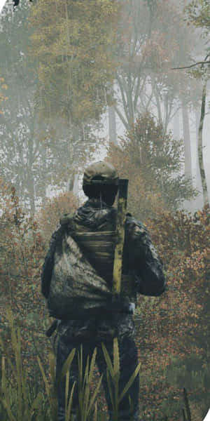 身穿迷彩裝備的士兵在煙霧瀰漫的秋林中手持步槍。 — 森林景色 壁紙
