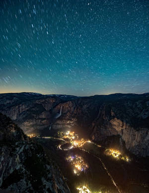 星軌越過被雪覆蓋的峽谷山谷，夜晚村莊燈火閃爍。