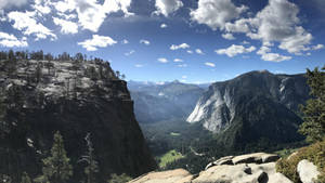 壯麗的山景，懸崖、森林和遠處的山峰在晴朗的天空下。