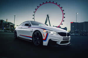 白色BMW M4 Performance跑車在黃昏時停泊在拉斯維加斯High Roller摩天輪前。