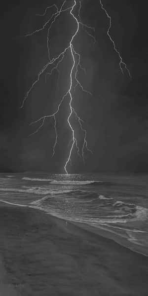 閃電在夜間擊中黑暗海灘上的海洋。