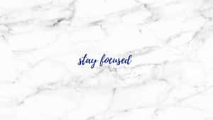 白色大理石表面，帶有海軍藍草書文字，寫著「stay focused」。 — 攝影師 壁紙