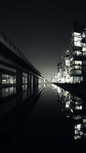 夜晚平靜水面上倒映的現代城市建築。