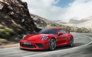 紅色保時捷911 GT3 RS在模糊背景的山路上疾馳。