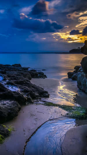 黃昏時分海洋上的夕陽，岩石和沙灘
