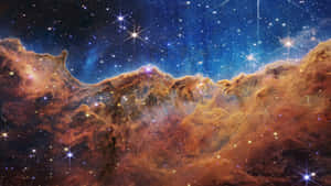 在深空中帶有發光星星的彩色星雲。 — 金粉 壁紙