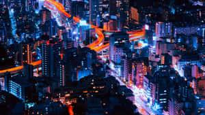 夜晚鳥瞰發光的城市景觀，霓虹燈和高速公路。